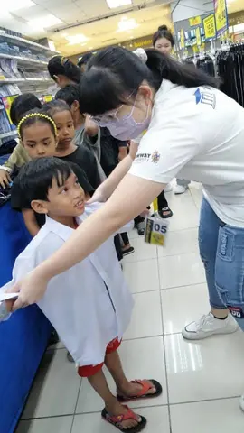 Volunteer fitting a child's school uniform