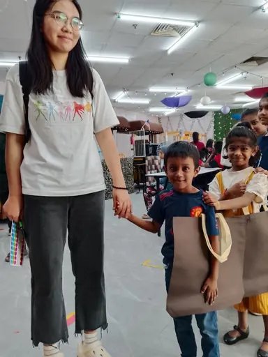 Volunteer and child shopping for school supplies