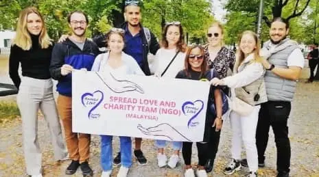 Spread Love and Charity Team volunteers holding the foundation banner